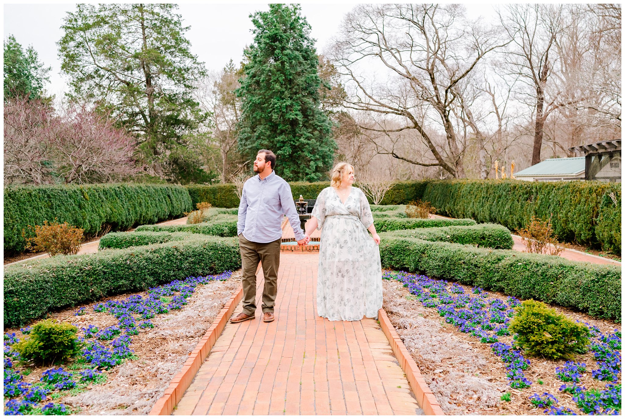couple holding hands during their engagement session in a garden