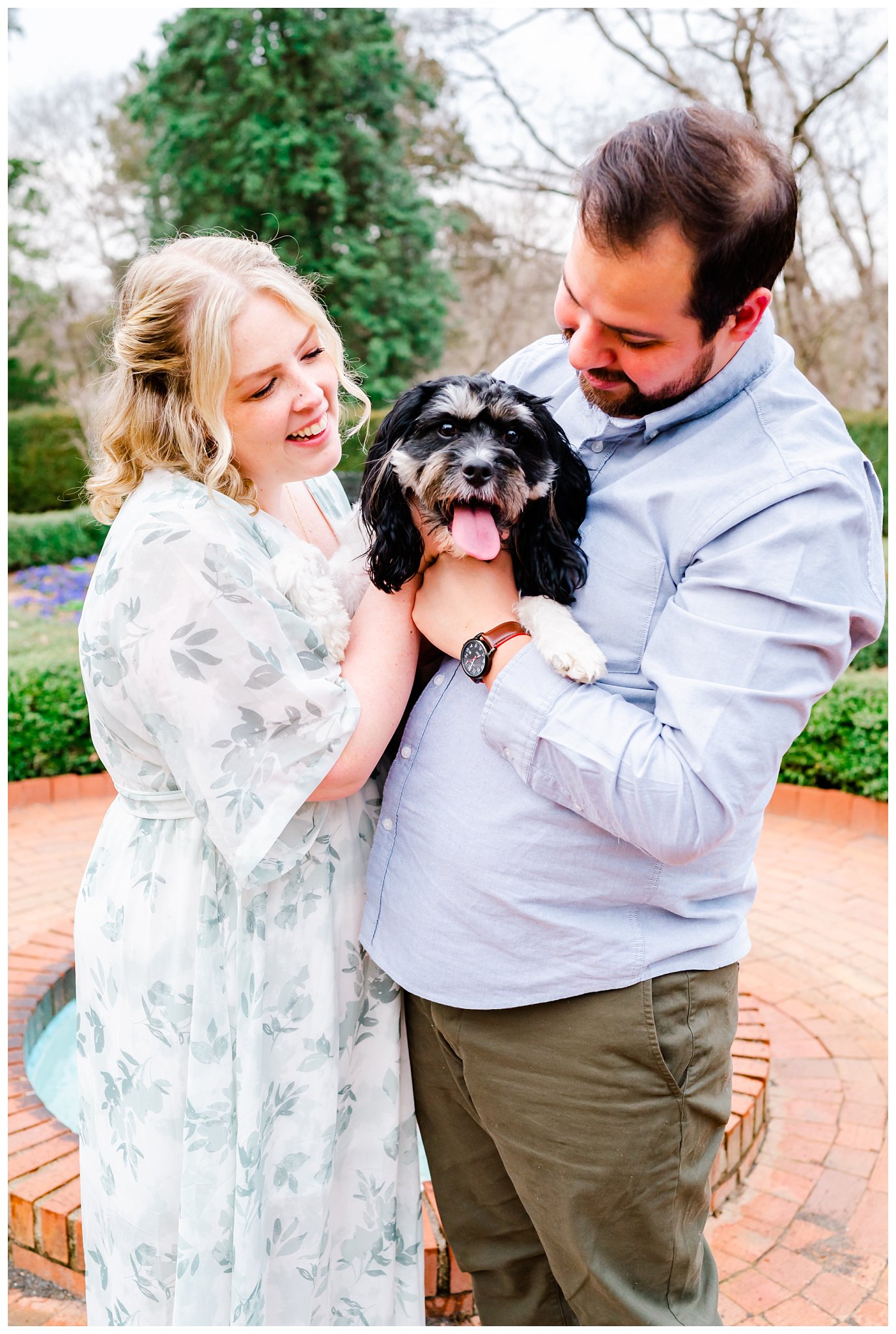 a couple and their dog outdoors at a park for their engagement session