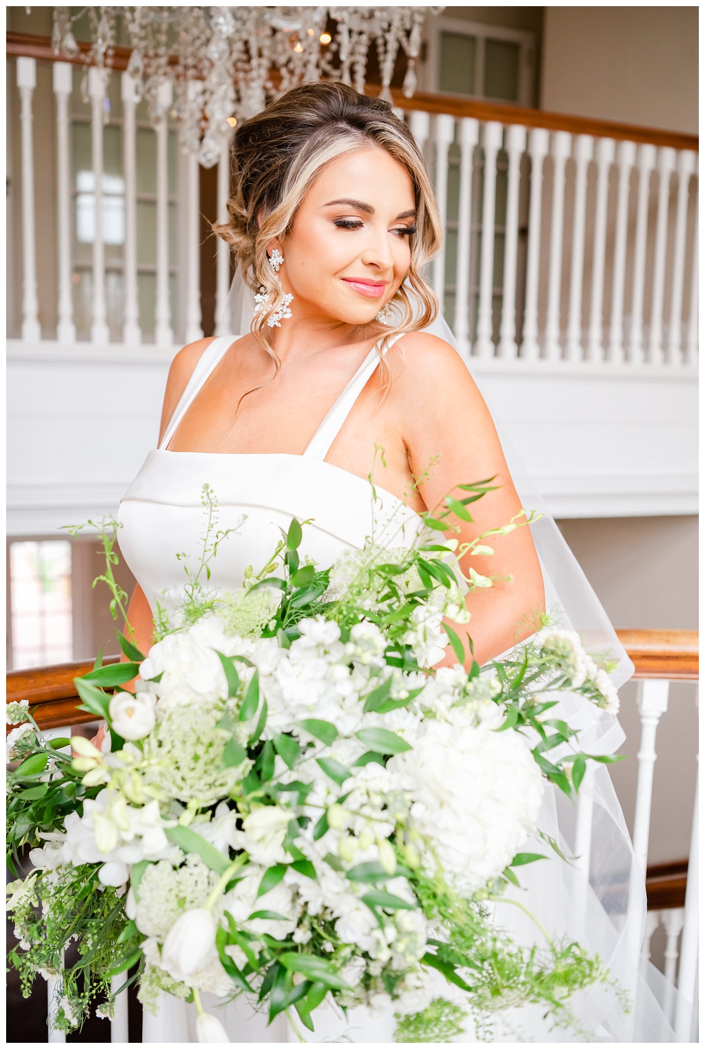 bride holding large green and white bouquet