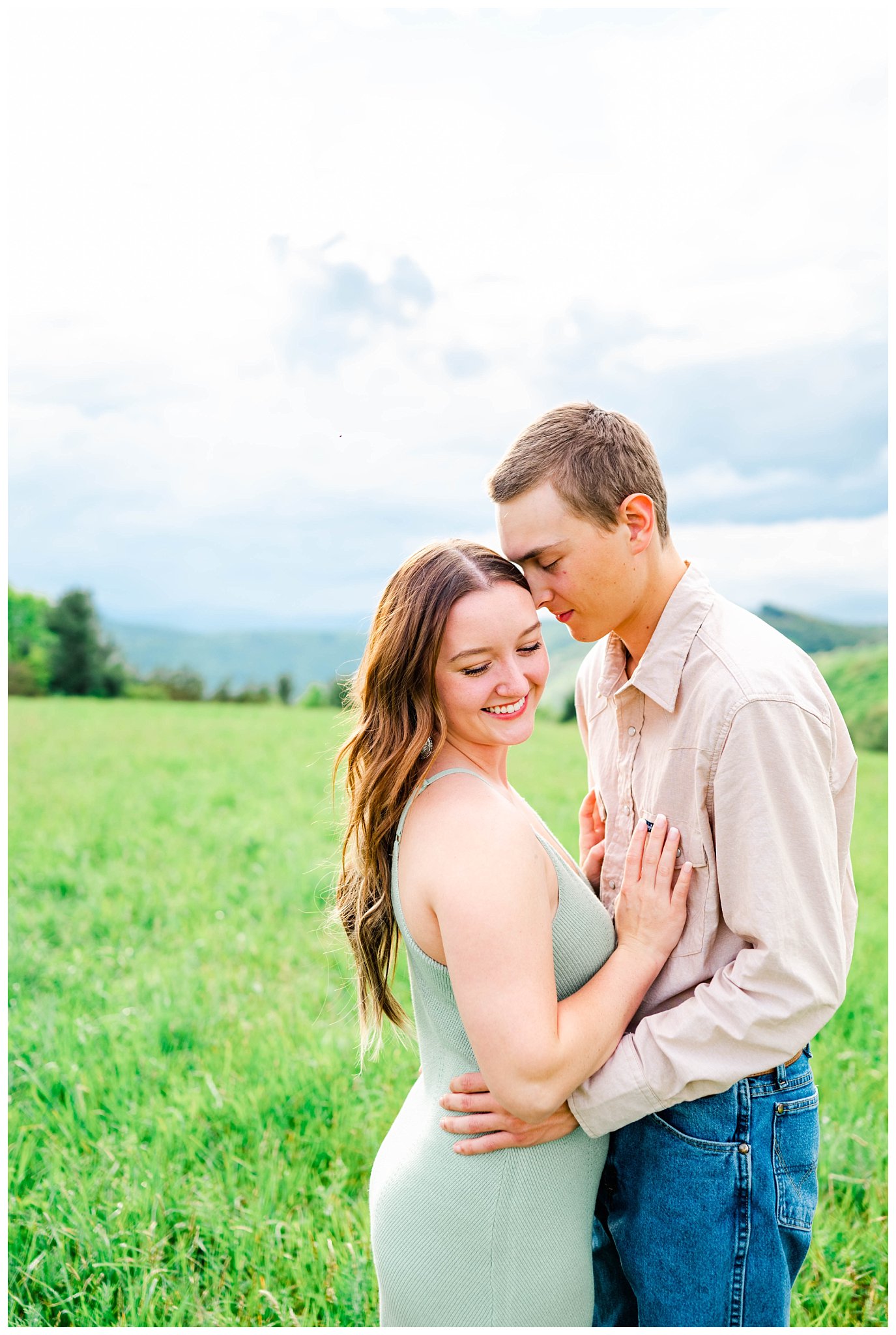 couple poses for their mountaintop engagement session