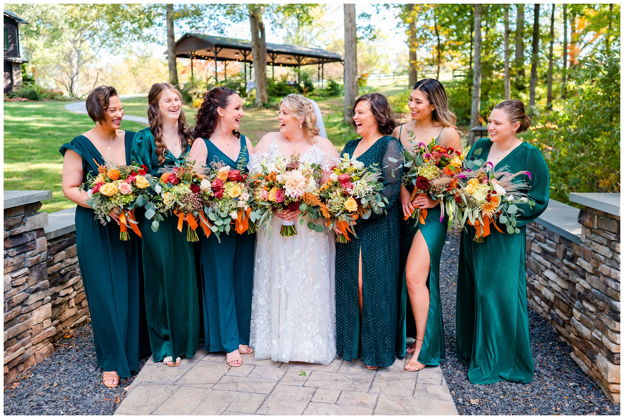 bride poses with her bridesmaids in green dresses for equestrian farm wedding