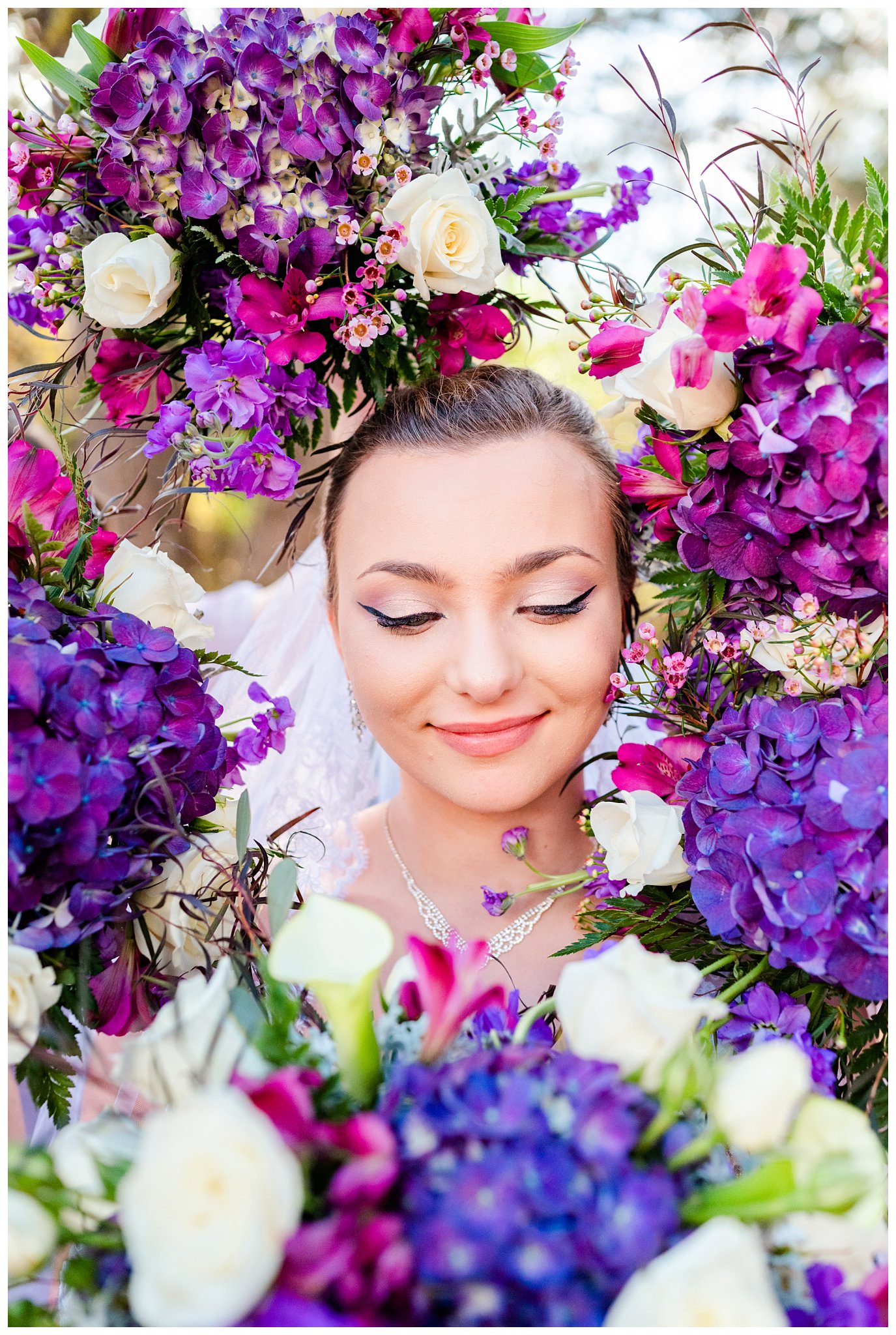 bride poses with purple flowers for her North Carolina vineyard wedding
